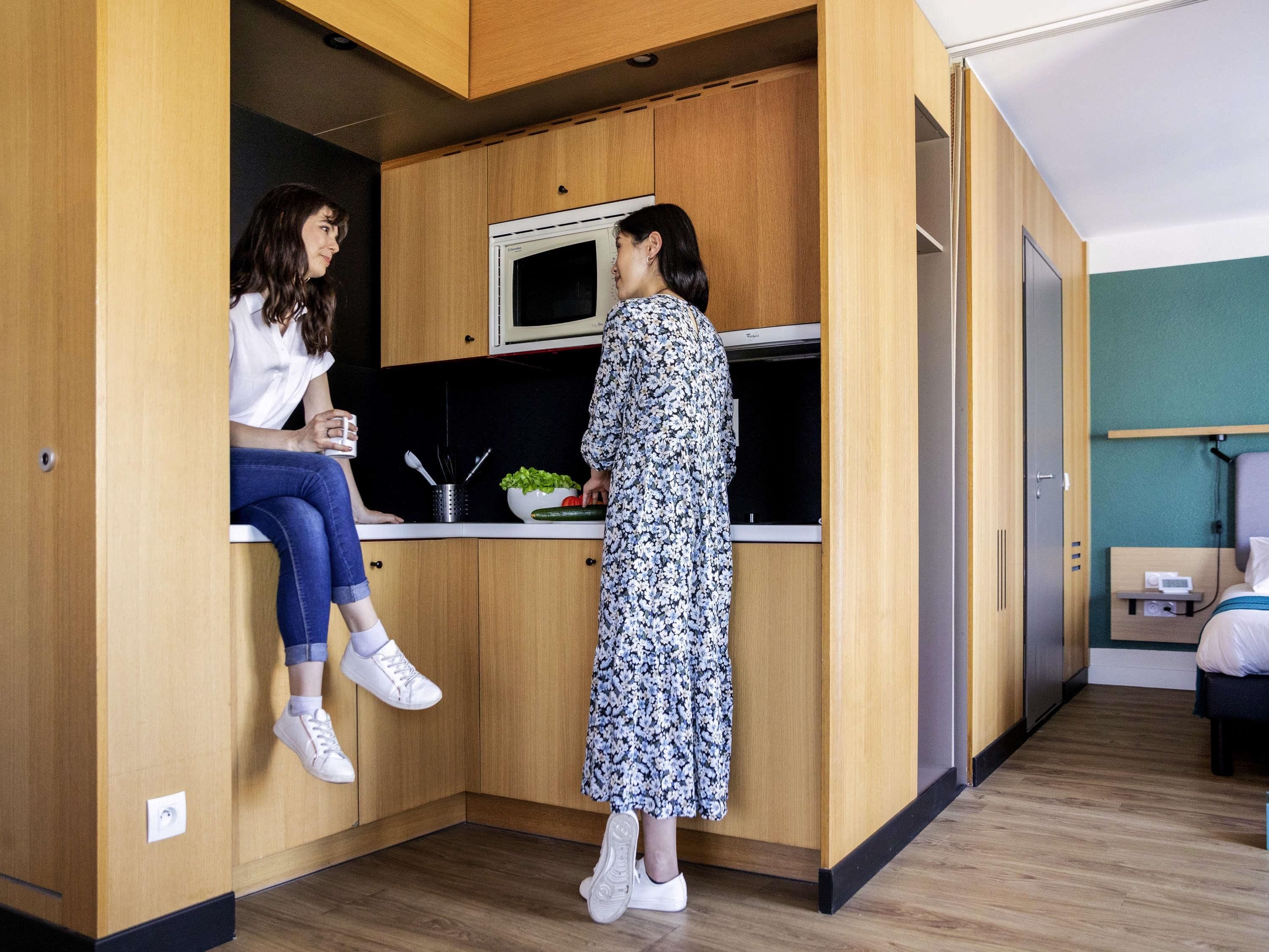 A compact kitchen with wooden cabinets, a microwave, and a sink.