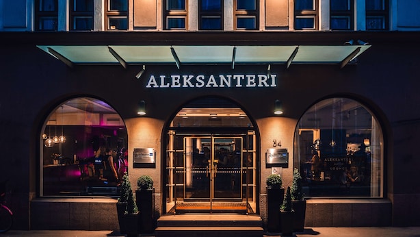The exterior of the Aleksanteri building with a glass entrance and illuminated signage. - Radisson Blu Aleksanteri Hotel, Helsinki (Helsinki)