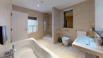 Un bagno moderno con vasca, doccia, water e lavandino.