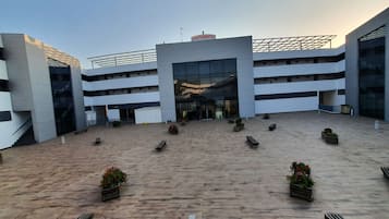 Un bâtiment moderne doté d’une entrée centrale, de plusieurs étages et d’un toit plat.