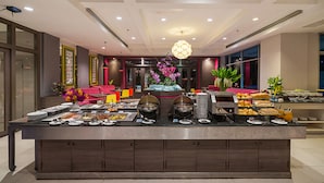 A buffet setup with various food items and a decorative centerpiece. - SUNSHINE VISTA (Pattaya)