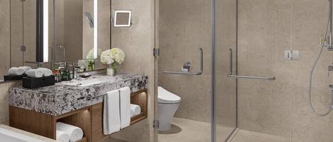 A modern bathroom with a glass-enclosed shower, a marble sink, and a toilet.