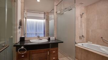 A modern bathroom with a glass shower enclosure, a bathtub, and a vanity with a sink and mirror.