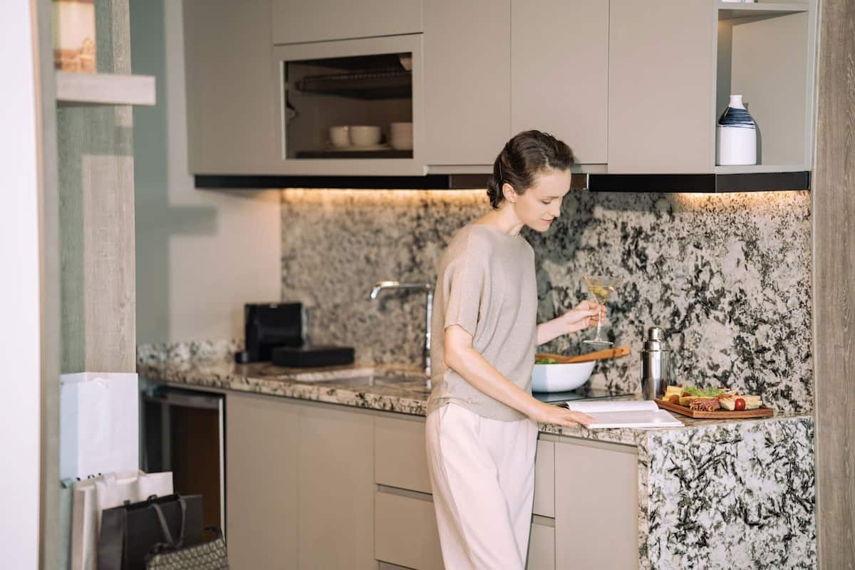 A kitchen with a marble countertop, a coffee machine, and a bowl of food.
