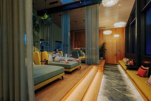Una sala de estar moderna con sofás, una mesa de centro y un amplio ventanal.
