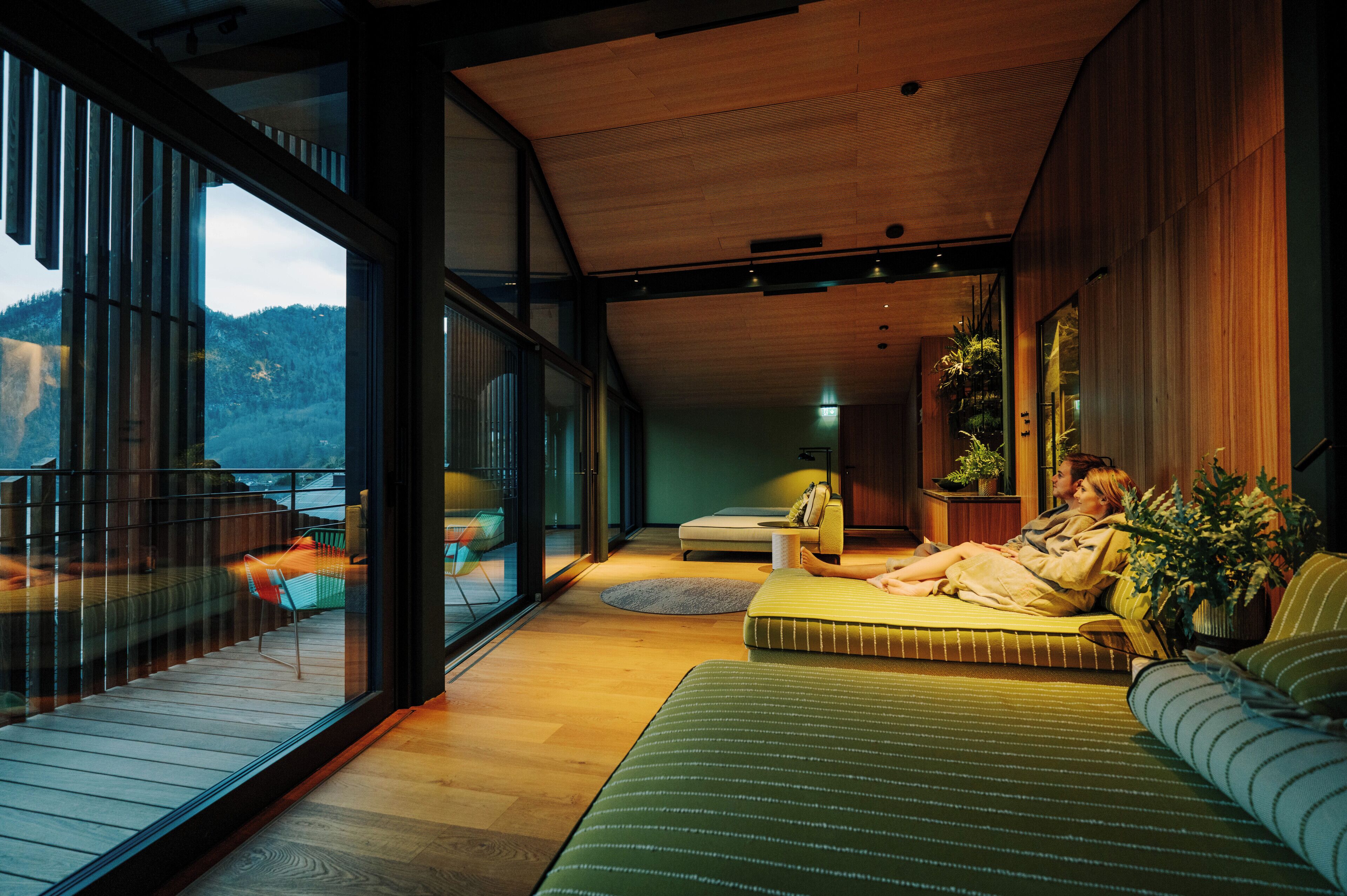 A modern interior with a large bed, a sofa, and a dining area.