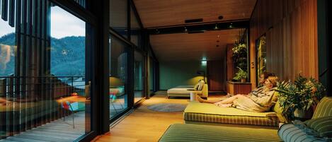 A modern interior with a large bed, a sofa, and a dining area.