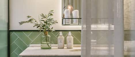 A bathroom with a mirror, a sink, and two bottles of lotion.