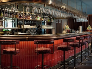 Enjoy a drink at the hotel bar, where a long counter and stools invite socializing.