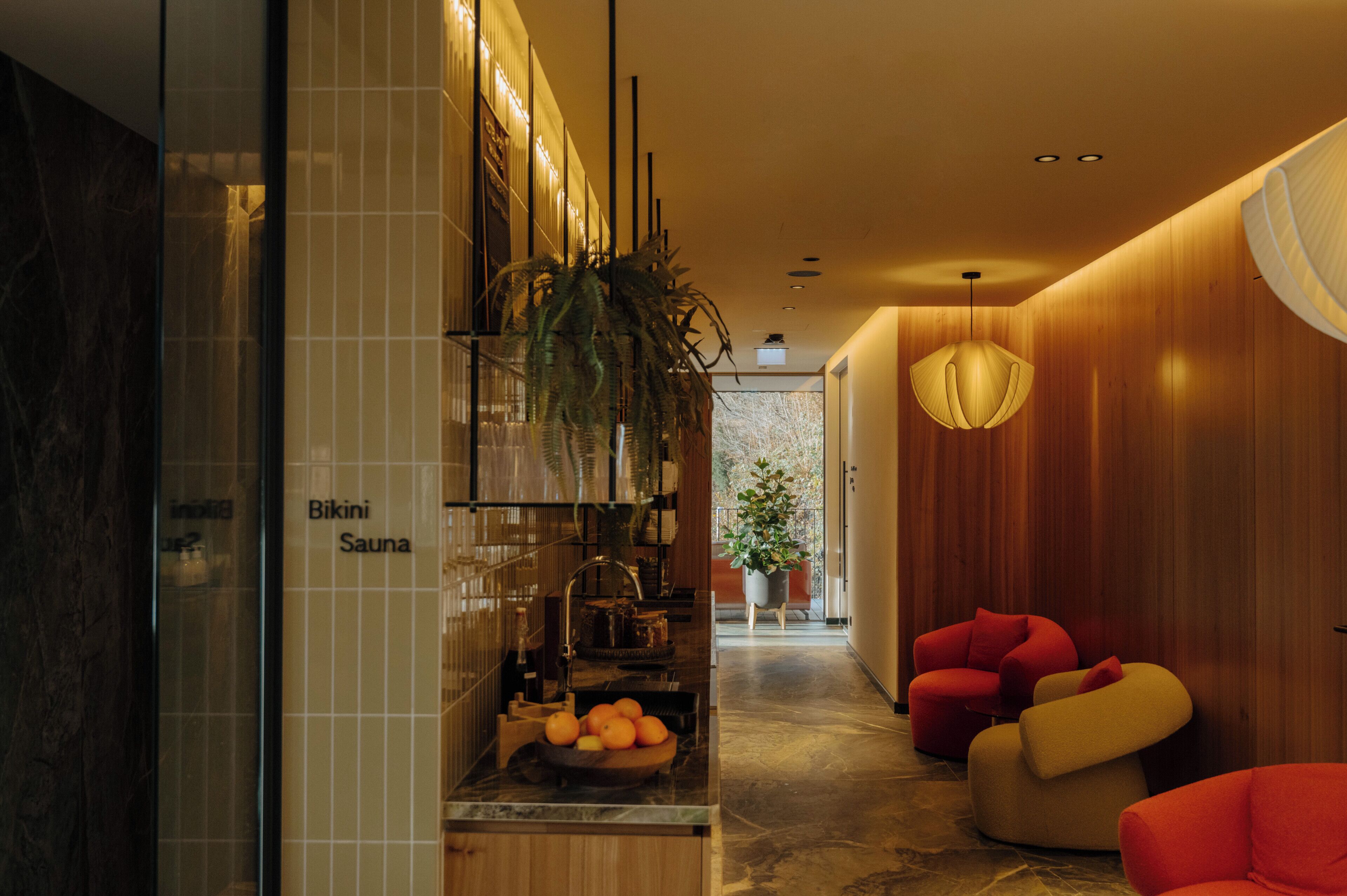 Ein modernes Interieur mit einer Rezeption, einer Pflanze und Sitzbereichen.