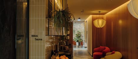 Ein modernes Interieur mit einer Rezeption, einer Pflanze und Sitzbereichen.