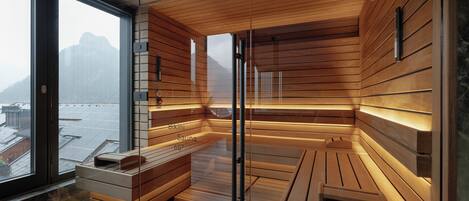Una sauna con bancos de madera y una pared de vidrio que ofrece vistas a un paisaje nevado.