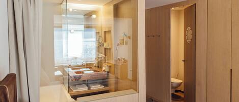 A modern bathroom with a glass-enclosed shower, a toilet, and wooden cabinetry.