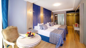 A hotel room with a bed, a chair, a table with fruit, and a small desk. - Aspen Hotel Istanbul (Istanbul)