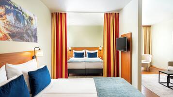 Una habitación de hotel con cama doble, televisión, escritorio y silla.