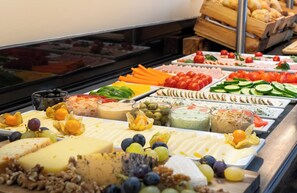 A buffet with various cheeses, fruits, and vegetables. - Leonardo Hotel Salzburg Airport (Wals-Siezenheim)