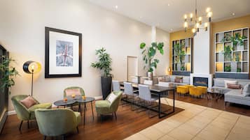 A modern living room with a dining area, a fireplace, and a large potted plant.