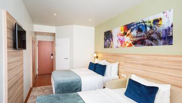 A hotel room with two beds, a TV mounted on the wall, and a large abstract painting.