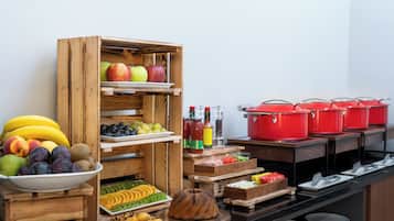 A buffet setup with various fruits, vegetables, and condiments.