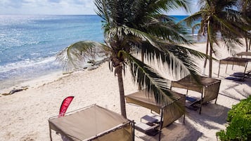 On the beach, white sand, sun loungers, beach umbrellas
