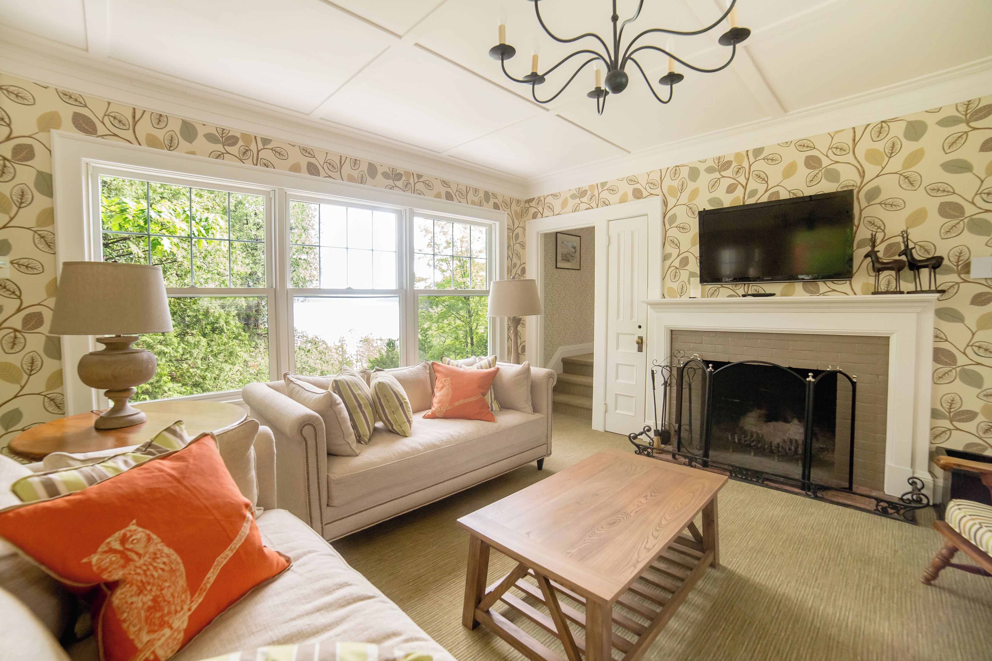 A cozy living room with a fireplace, a sofa set, and a television.