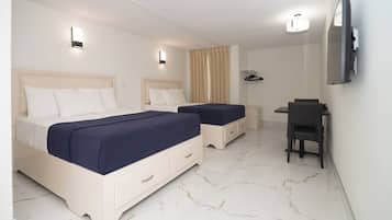 Une chambre d’hôtel avec deux lits, un bureau, une chaise et un téléviseur fixé au mur.