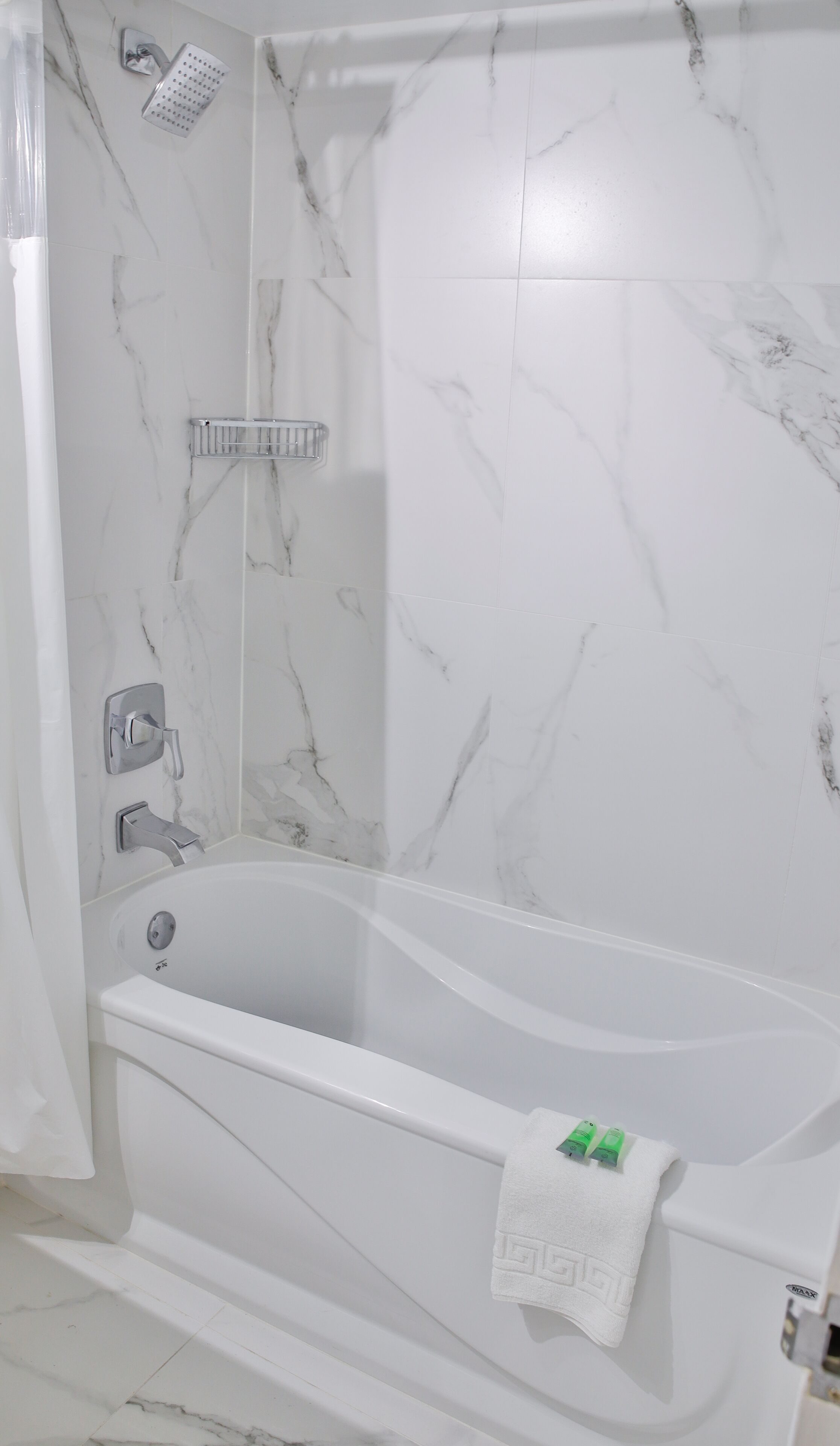 A modern bathroom with a freestanding bathtub, a showerhead, and a towel rack.