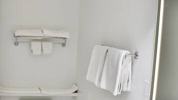 Un bagno moderno con lavandino, water e portasciugamani bianchi.