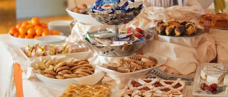 A buffet table with various desserts and pastries.