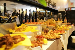 Una mesa de buffet con diferentes alimentos y botellas de vino.