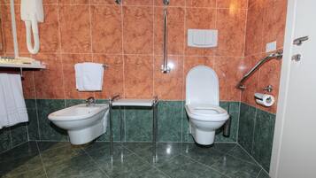 Un bagno con bidet, WC e asciugamani ad aria.