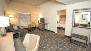 Une chambre d’hôtel équipée d’un canapé, d’un fauteuil, d’un bureau et d’un lit.