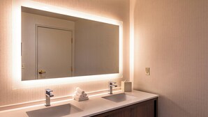 A bathroom with two sinks, a large mirror, and a wooden vanity. - Holiday Inn & Suites Oakland Airport by IHG (Oakland)