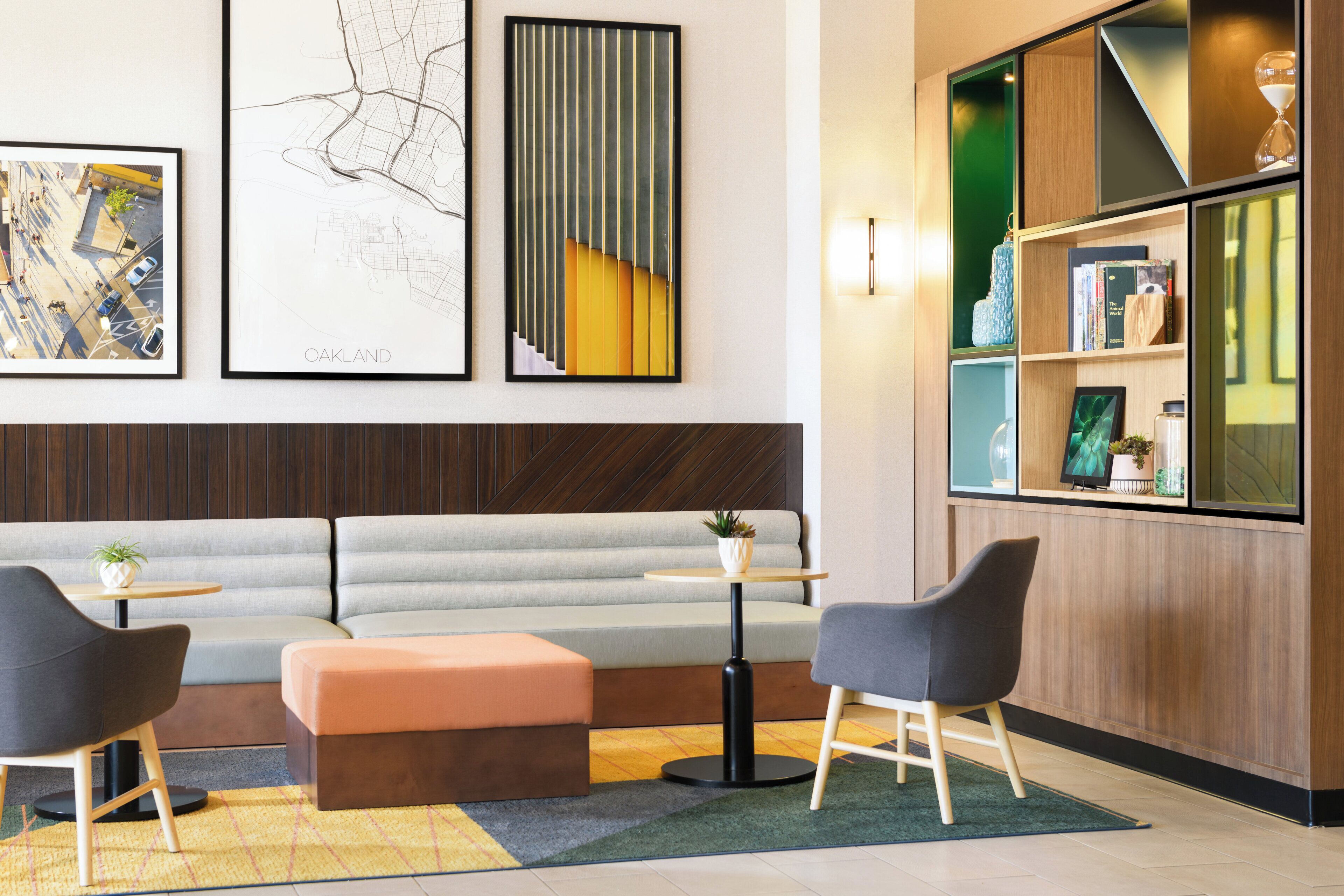 A modern interior with a sofa, two chairs, a small table, and a bookshelf.