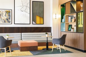 Un interior moderno con un sofá, dos sillones, una mesita y una estantería.