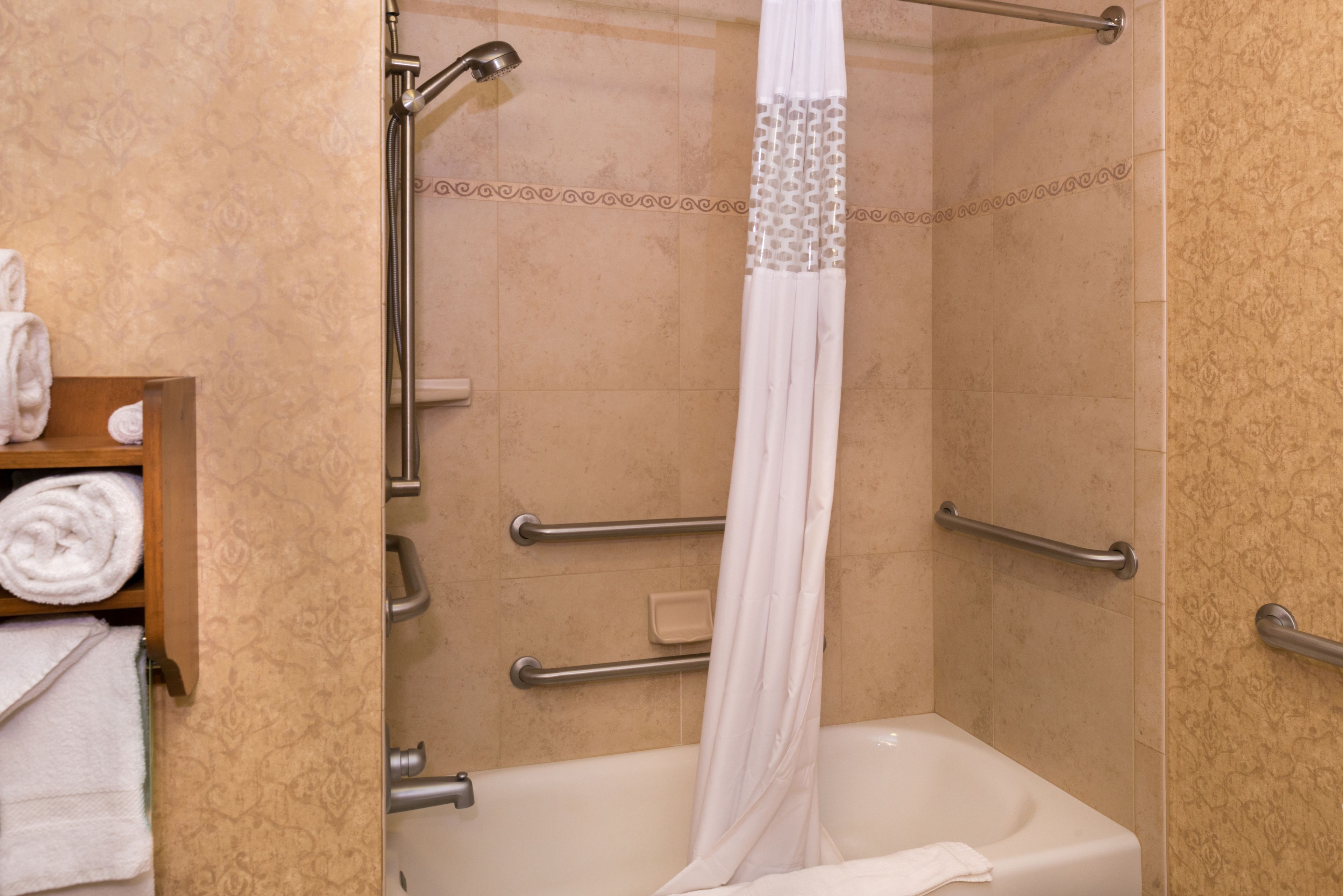 Un baño con ducha, bañera y toallero.