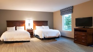 A hotel room with two beds, a nightstand with a lamp, a dresser, and a TV. - Hampton Inn Gloucester (Gloucester)