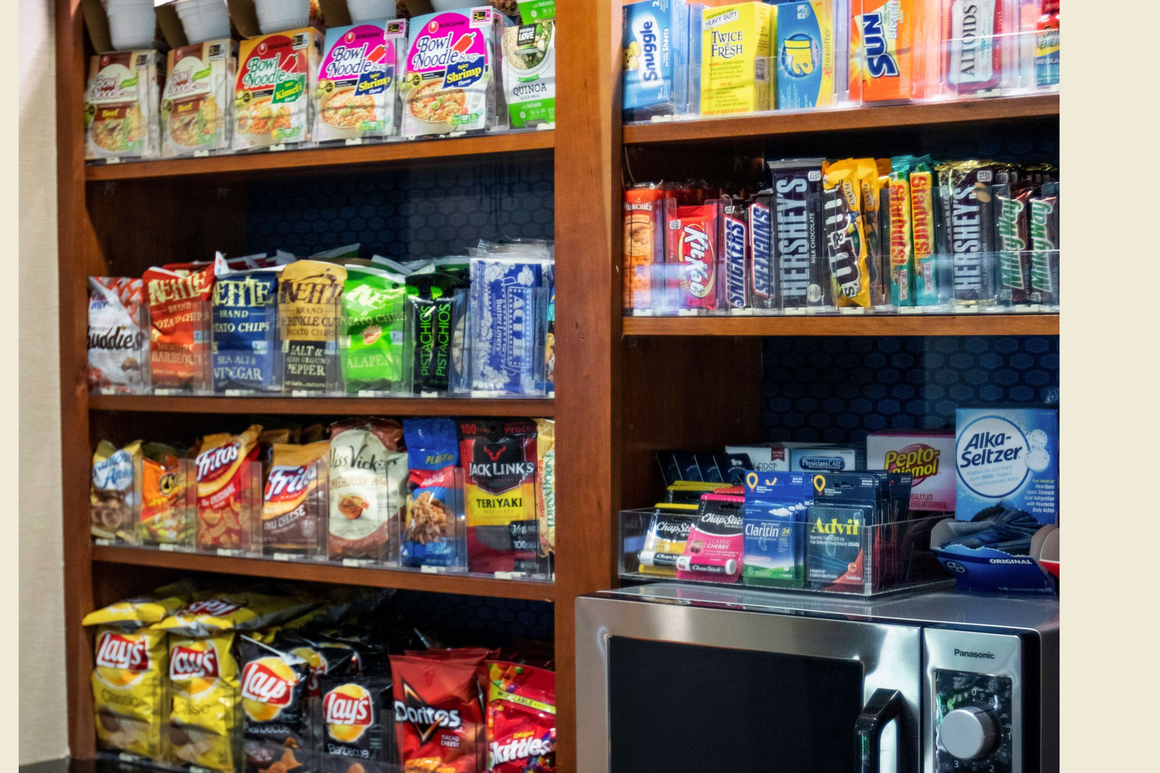Shelves stocked with various snacks and packaged foods, including chips, noodles, and candy.