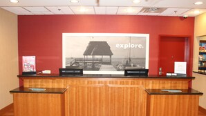 A reception desk with a large poster of a beach scene and the word "explore."