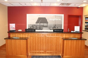 A reception desk with a large poster of a beach scene and the word "explore."