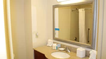 A bathroom with a sink, mirror, and towel rack.