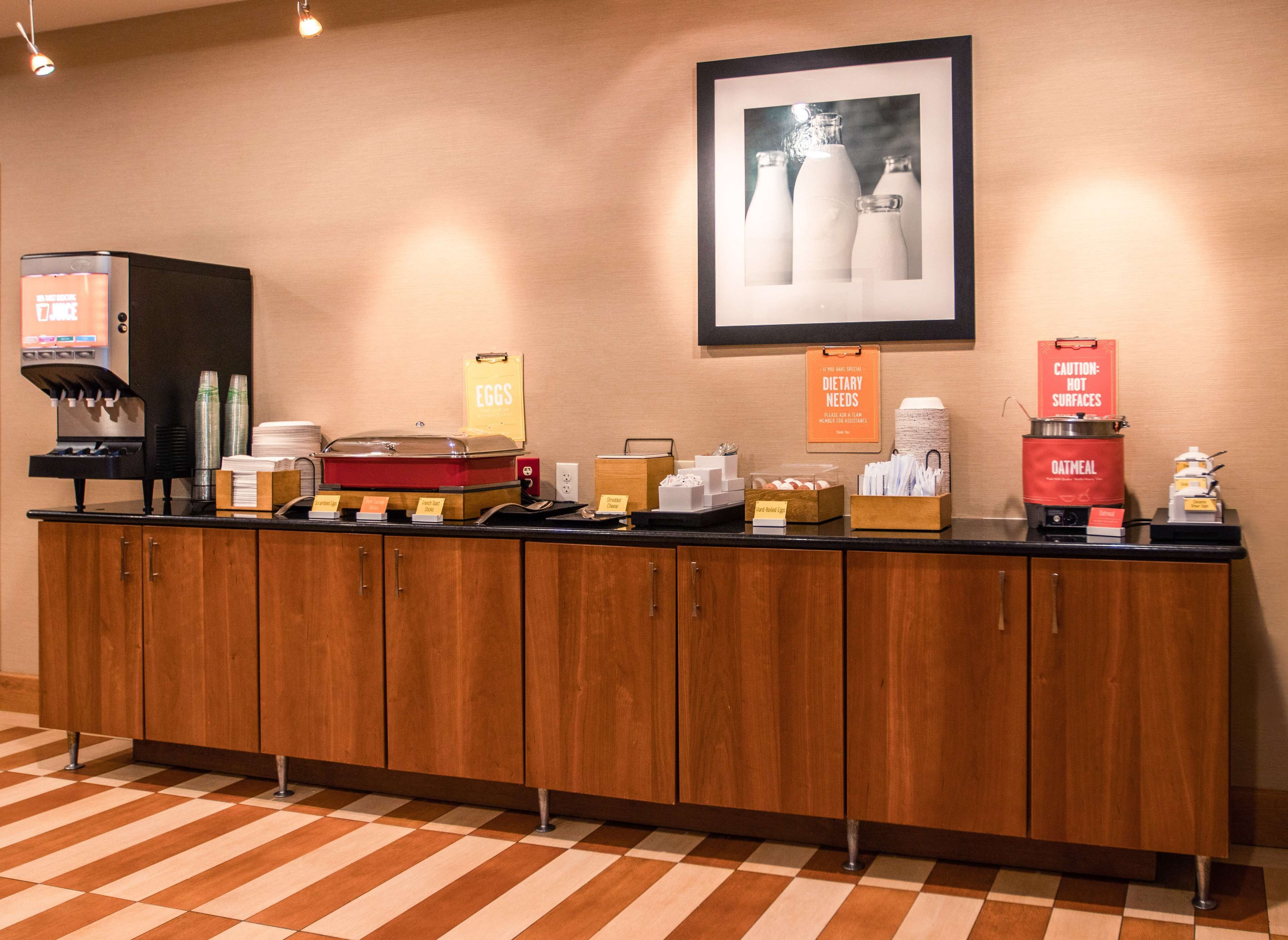 A breakfast bar with various food items and a coffee machine.