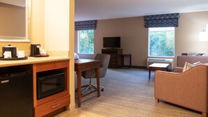 A compact hotel room with a kitchenette, a dining area, a TV, and a sofa. - Hampton Inn Gloucester (Gloucester)