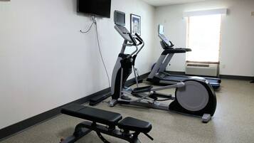 A gym with treadmills, an elliptical, and a bench.