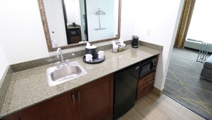 A hotel bathroom with a sink, mirror, and a coffee maker. - Hampton Inn & Suites Palm Coast (Palm Coast)