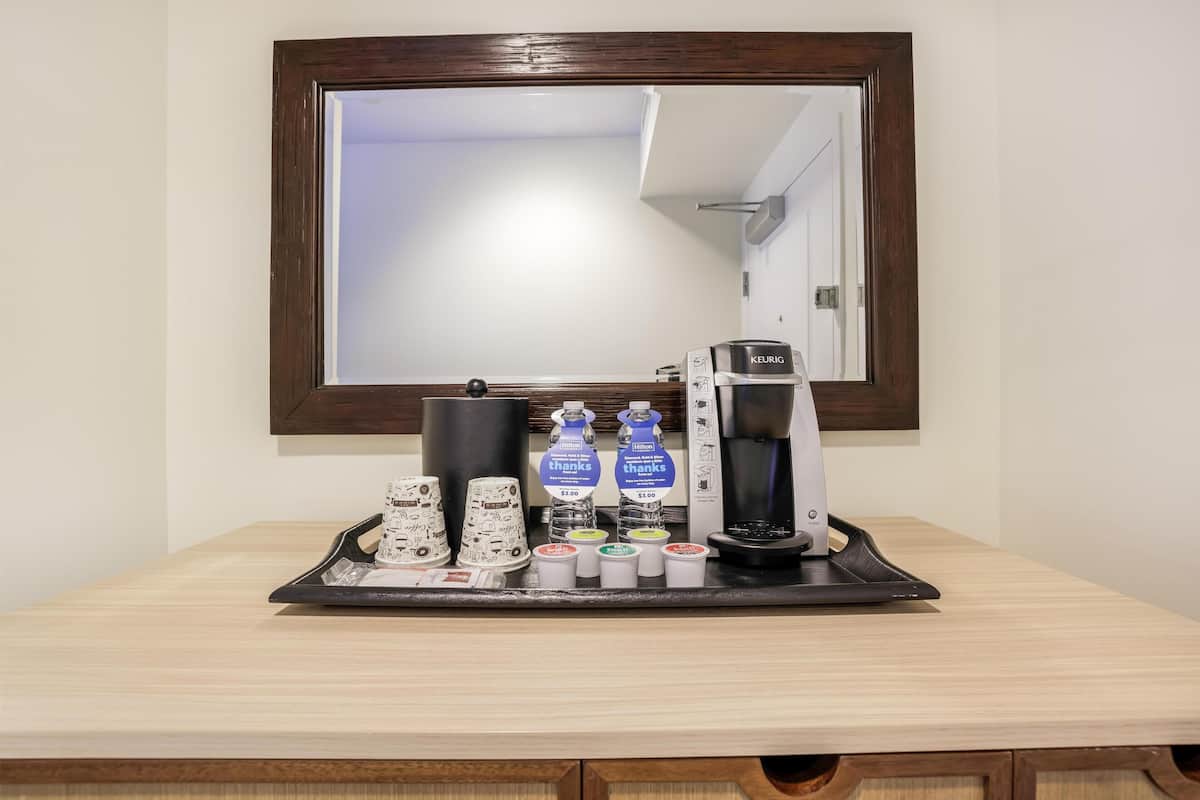 Eine Kaffeestation mit einer Keurig-Maschine, Einwegbechern und einem Tablett.