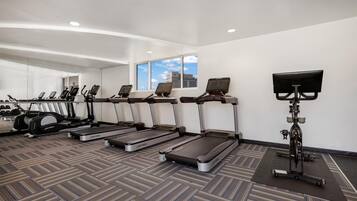 A gym with treadmills, a stationary bike, and a rowing machine.