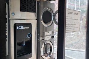 A laundry facility with an ice dispenser and a sign indicating it's for guest use only.
