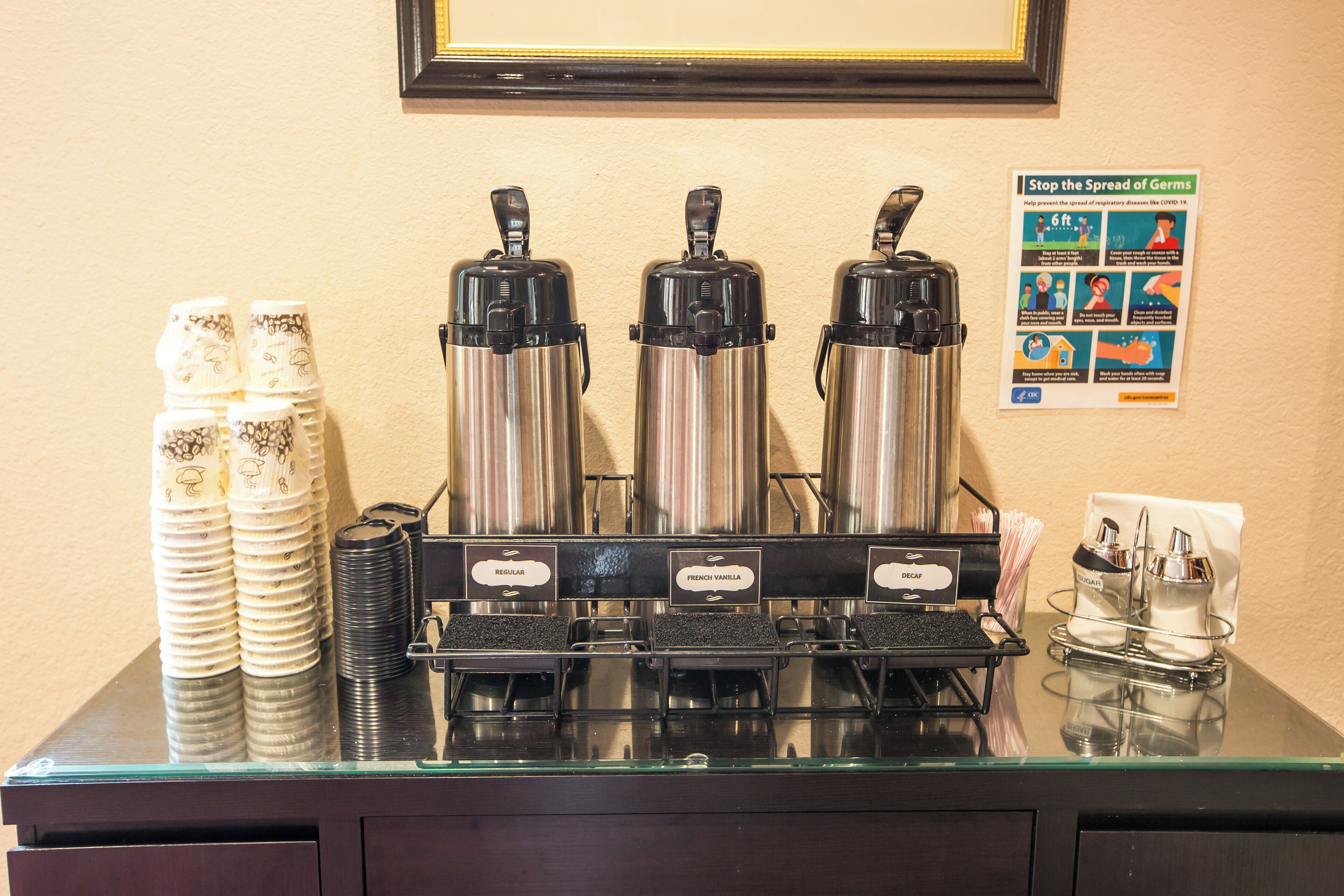 A coffee station with three dispensers labeled "Regular," "French Vanilla," and "Decaf."