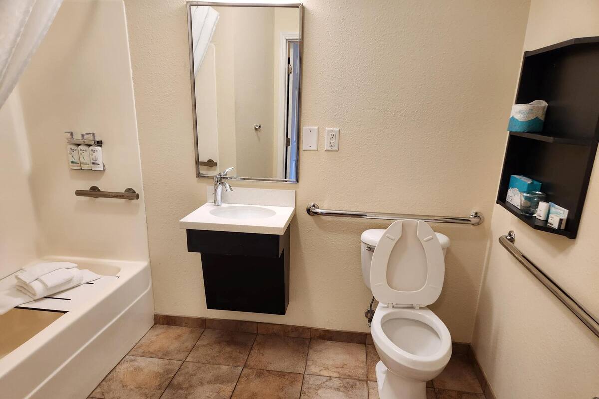 Une salle de bain avec une baignoire, un lavabo, des toilettes et un miroir.